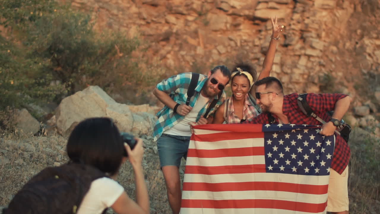 Group of friends taking pictures with the American flag