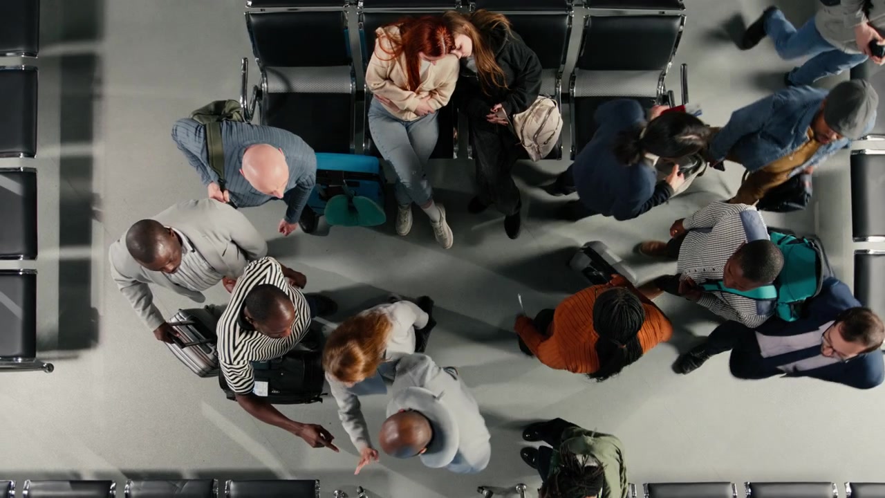 Top down view of people waiting in airport, checking flight schedule