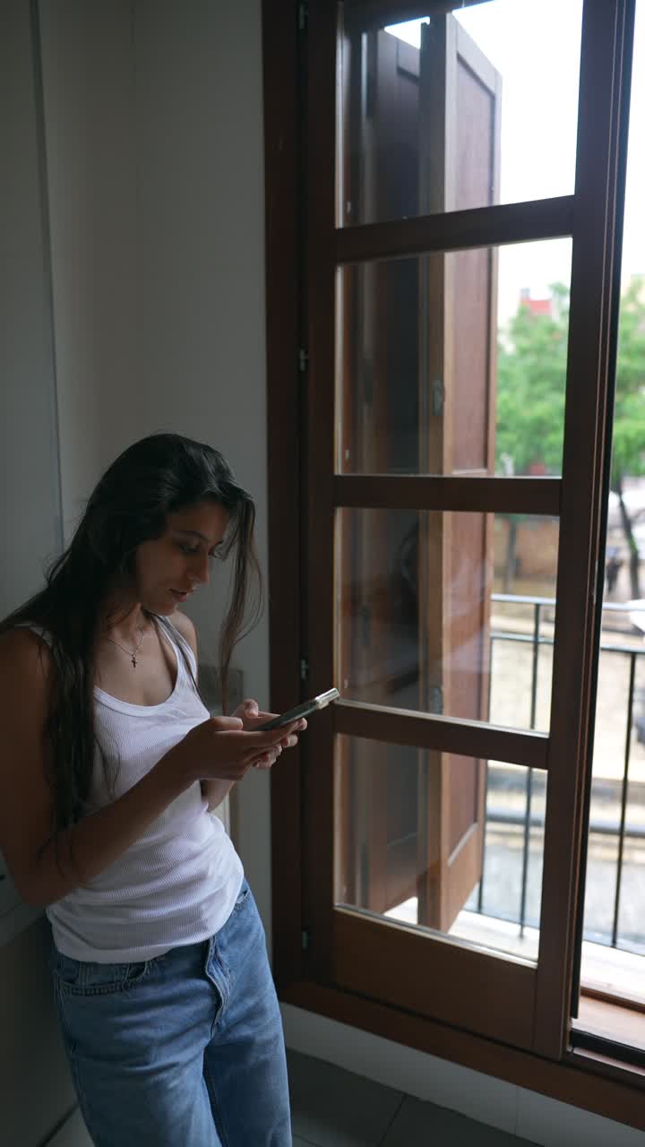 mujer joven usando el teléfono en la cocina de la casa