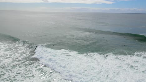 Surfer-Riding-The-Big-Ocean-Waves-Over-The-Cloudscape-Of-Blue-Sky-In-The-Beach-Of-Burleigh-Heads-National-Park-In-Australia