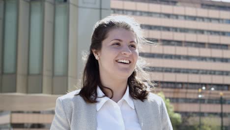 Front-view-of-smiling-young-woman-talking-to-someone-on-street