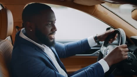 Side-view-driver-dancing-at-steering-wheel.-Man-moving-hands-front-at-car