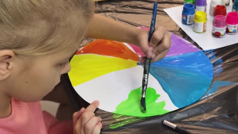 young girl painting a color wheel