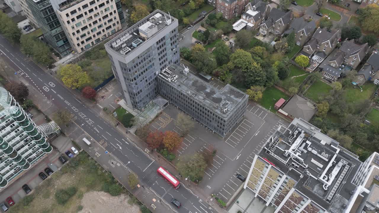 Orbital aerial perspective capturing abandoned office building's deteriorating structure in urban Ealing, London, UK, October 2024