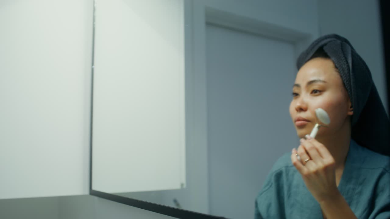 욕실 에서 얼굴 마사지 를 하는 여자