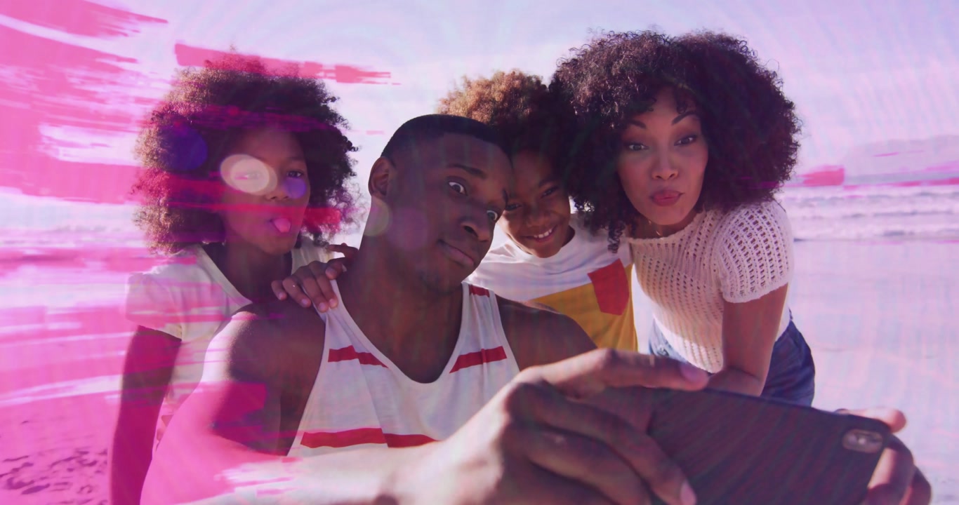 Taking selfie, family smiling together on beach with animation in sunny school day