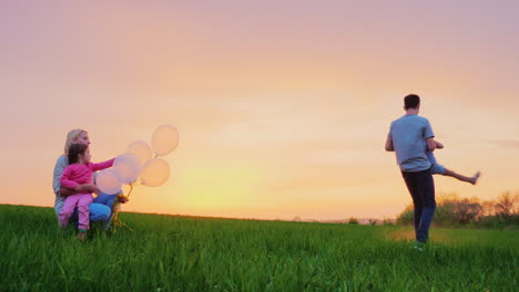 Ein-Glücklicher-Vater-Von-Zwei-Mädchen,-Der-Bei-Sonnenuntergang-Mit-Ihnen-Spielt