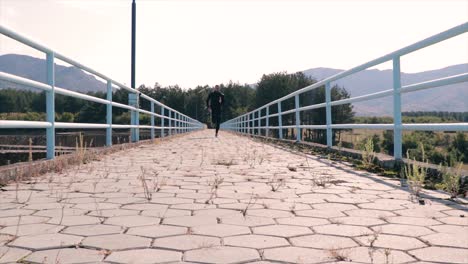 man running on a dam path with fences