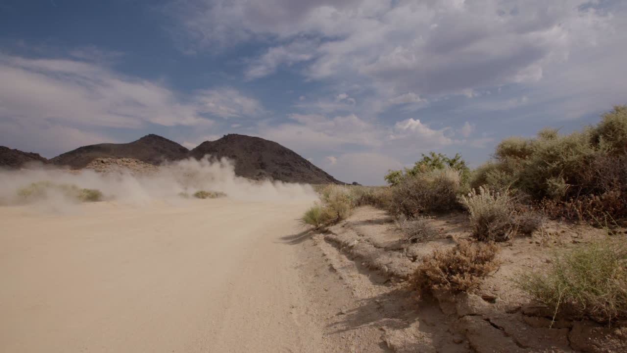 Slow-Motion dust from a car-truck on dirt desert road