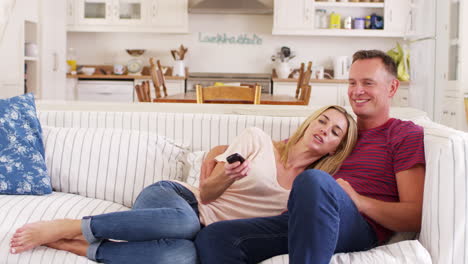 Pareja-Sentada-En-El-Sofá-Viendo-La-Televisión-Juntos