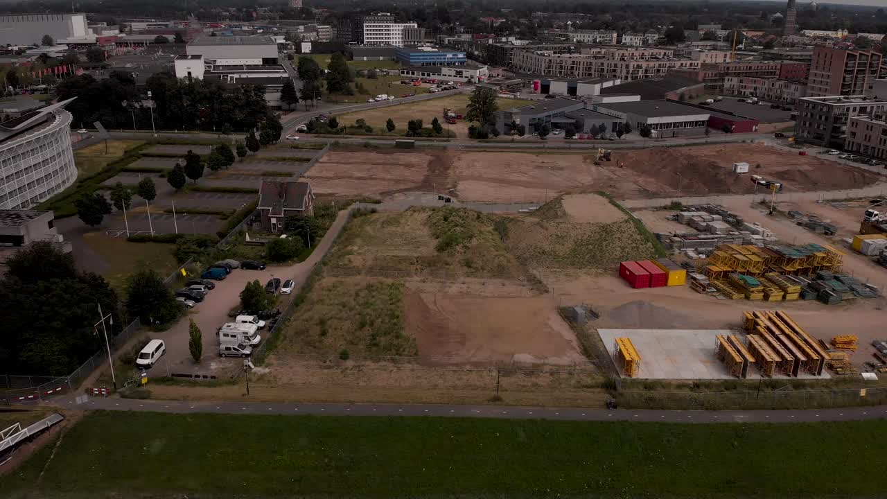 Slow sideways pan showing construction site at riverbank of river IJssel