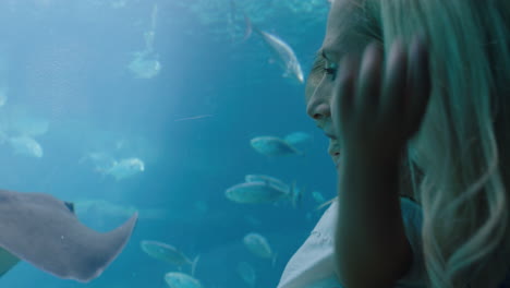 mother at child in aquarium looking at beautiful fish swimming in tank little girl watching marine animals with curiosity having fun learning about marine life with mom in oceanarium