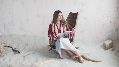 charming girl in an embroidered authentic ukrainian shirt and skirt poses and adjusts her hair while looking into the camera