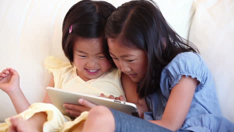 Two-sisters-using-a-tablet-computer-together