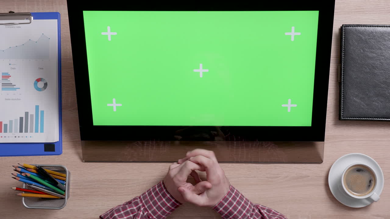 Office desk with computer and green screen