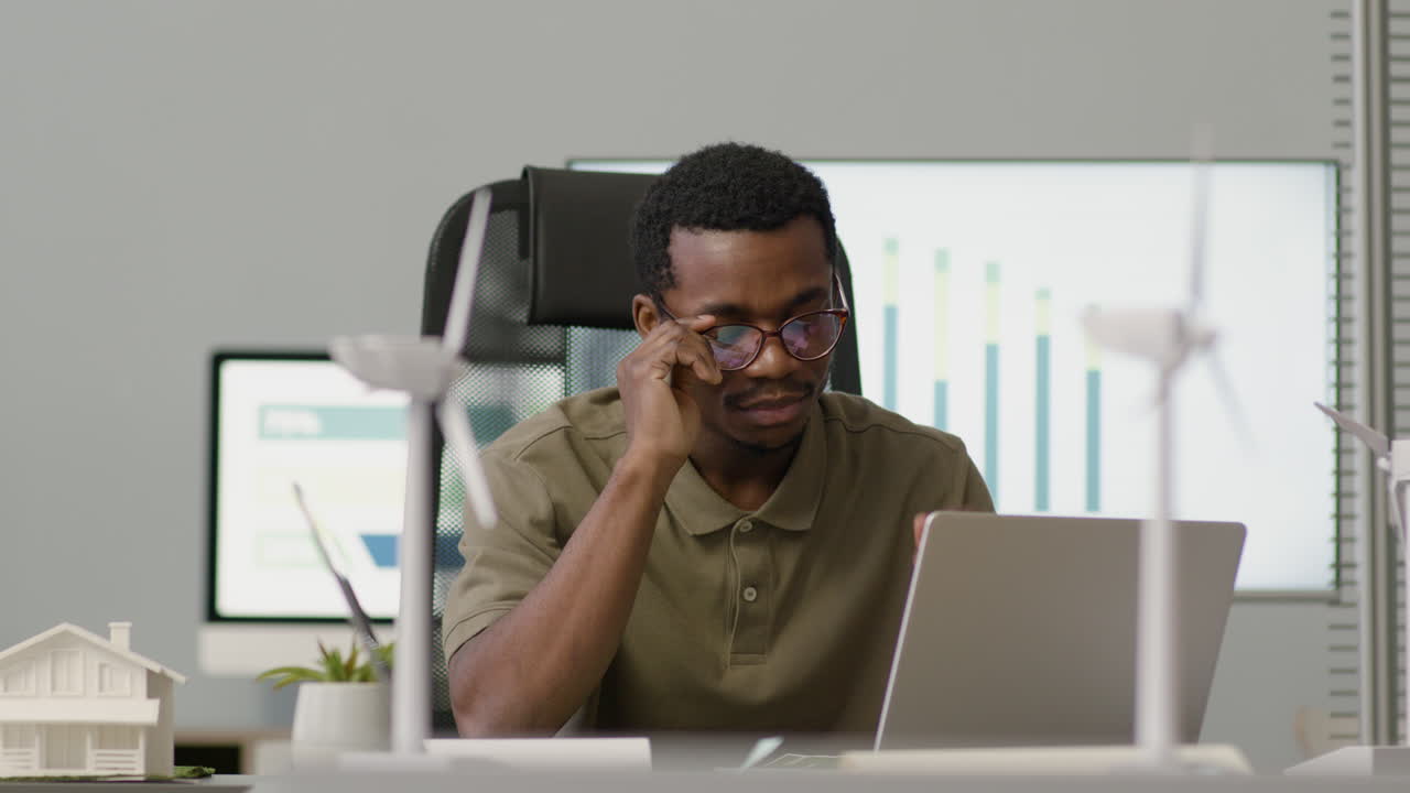 Man Working Using Laptop Sitting At Desk In The Office