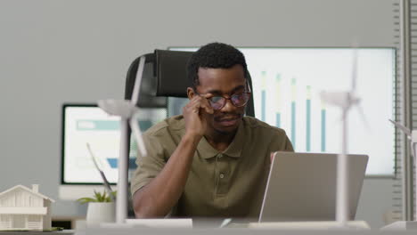 man working using laptop sitting at desk in the office