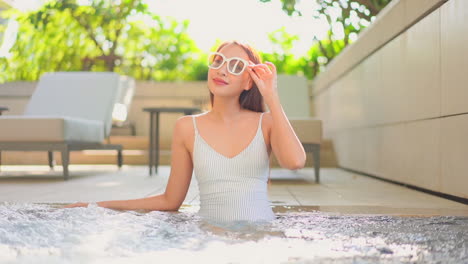 Mujer-Asiática-Con-Gafas-De-Sol-Se-Relaja-En-La-Piscina-De-Jacuzzi-De-Hidromasaje