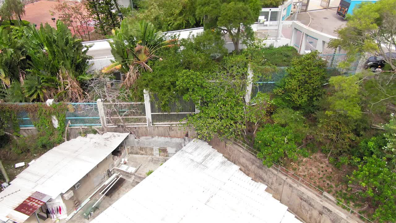 Hong Kong rundown slum houses populated by squatters, in the outskirts of Kowloon bay, Aerial Tilt up to city skyline