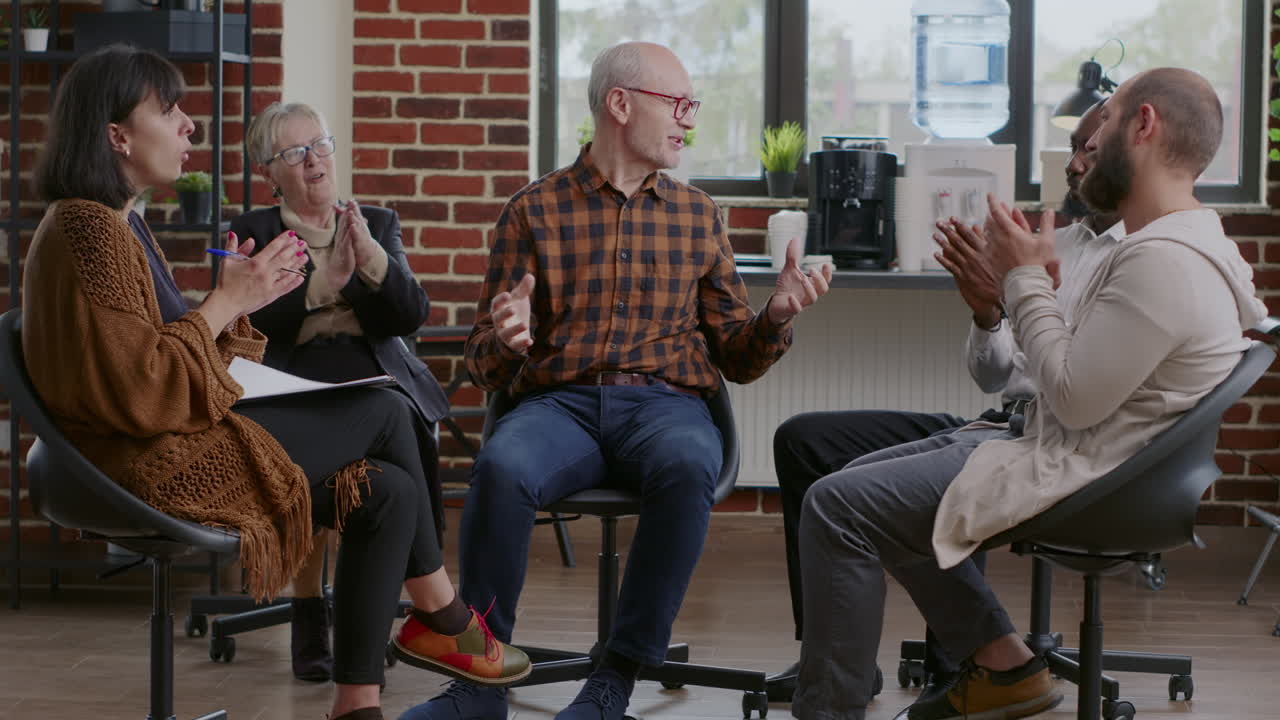 Senior man sharing progress and shaking hands to celebrate success with people at aa meeting