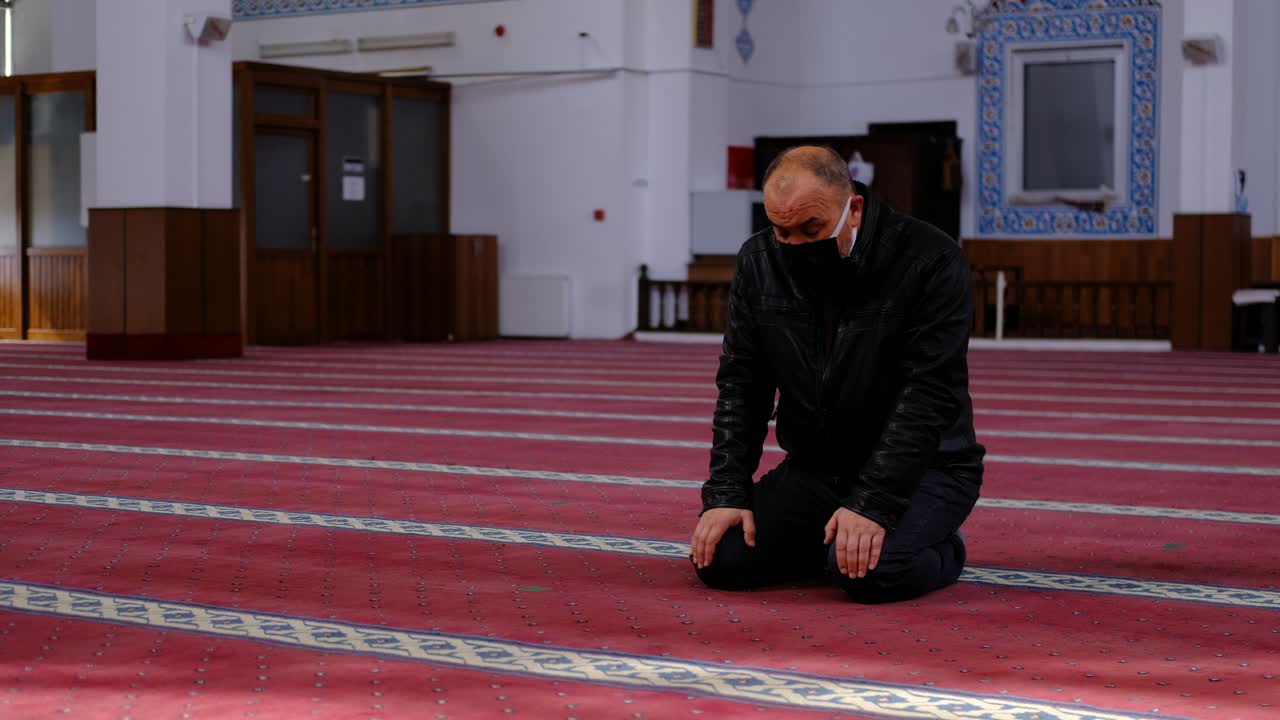 마스크를 쓴 노인이 머리를 모스크로 돌린다