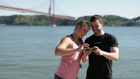 dos personas deportivas mirando su teléfono inteligente.