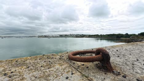 storm clouds time lapse rolling across holyhead harbour seafront beside rusted ships mooring ring