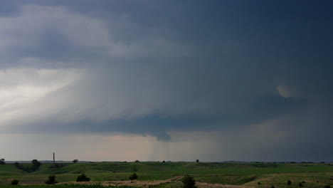 dramatic storm clouds gathering over green rolling hills