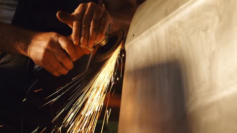 Male-mechanic-using-grinder-machine-in-garage-4k