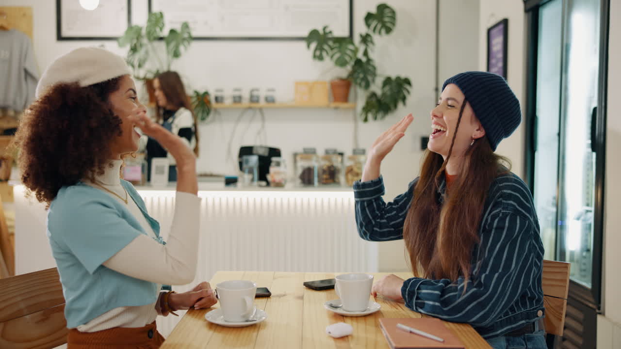 Two women laughing in a cafe