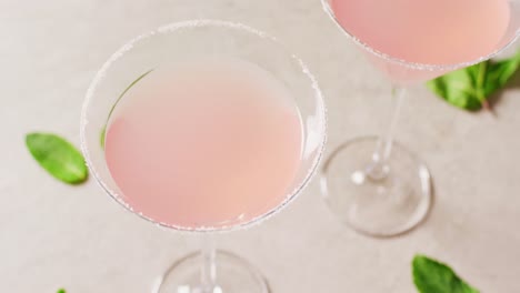 close up of drinks with sugar over basil on white table