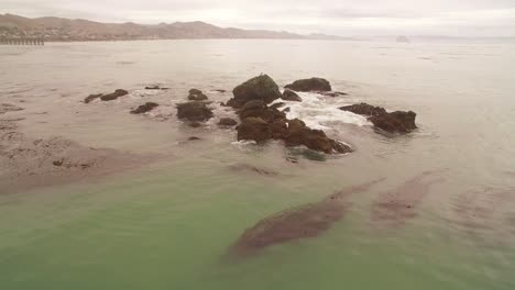 waves crashing against rocks on a gloomy day