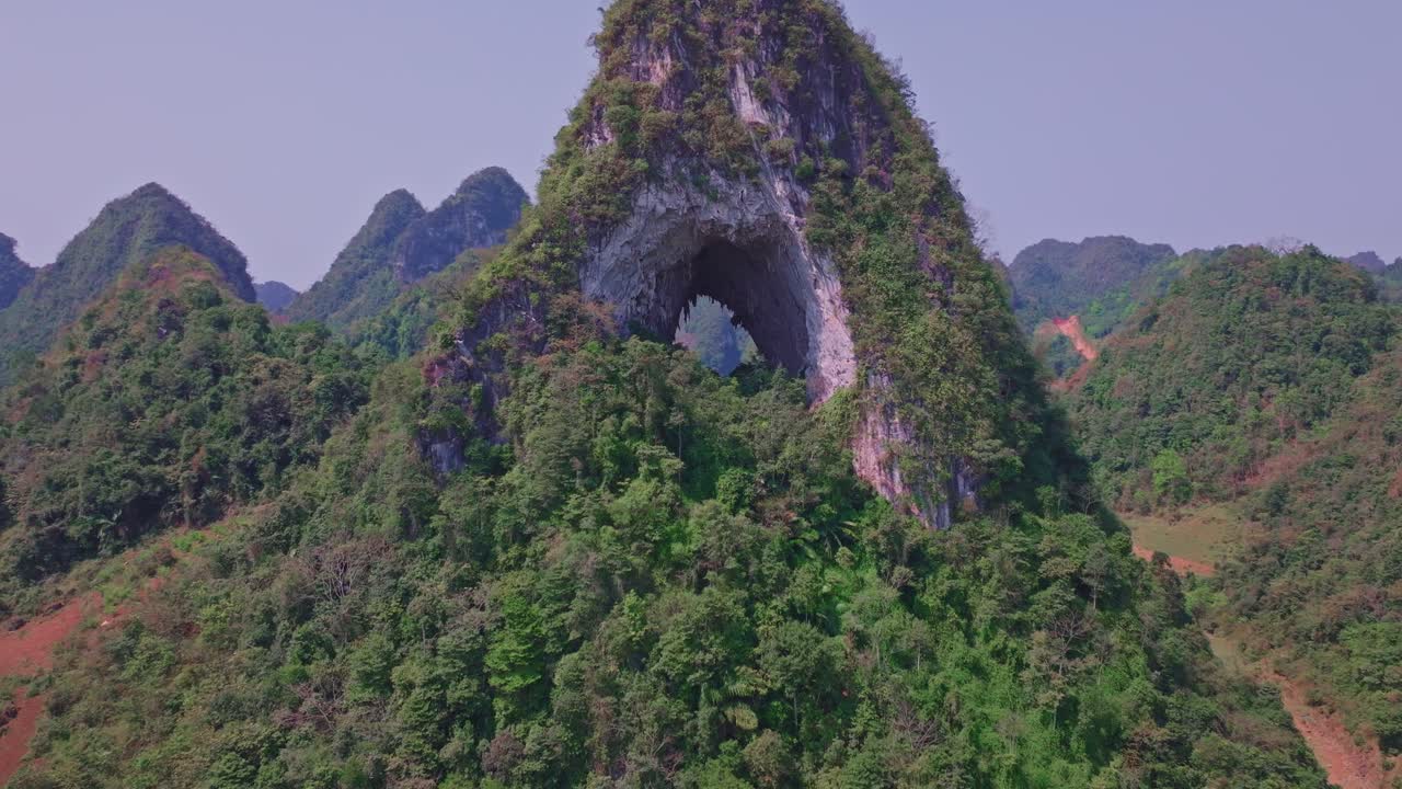 esta grabación de dron captura un impresionante primer plano del majestuoso arco natural en la montaña angel eye, ubicada en cao bang, vietnam del norte.