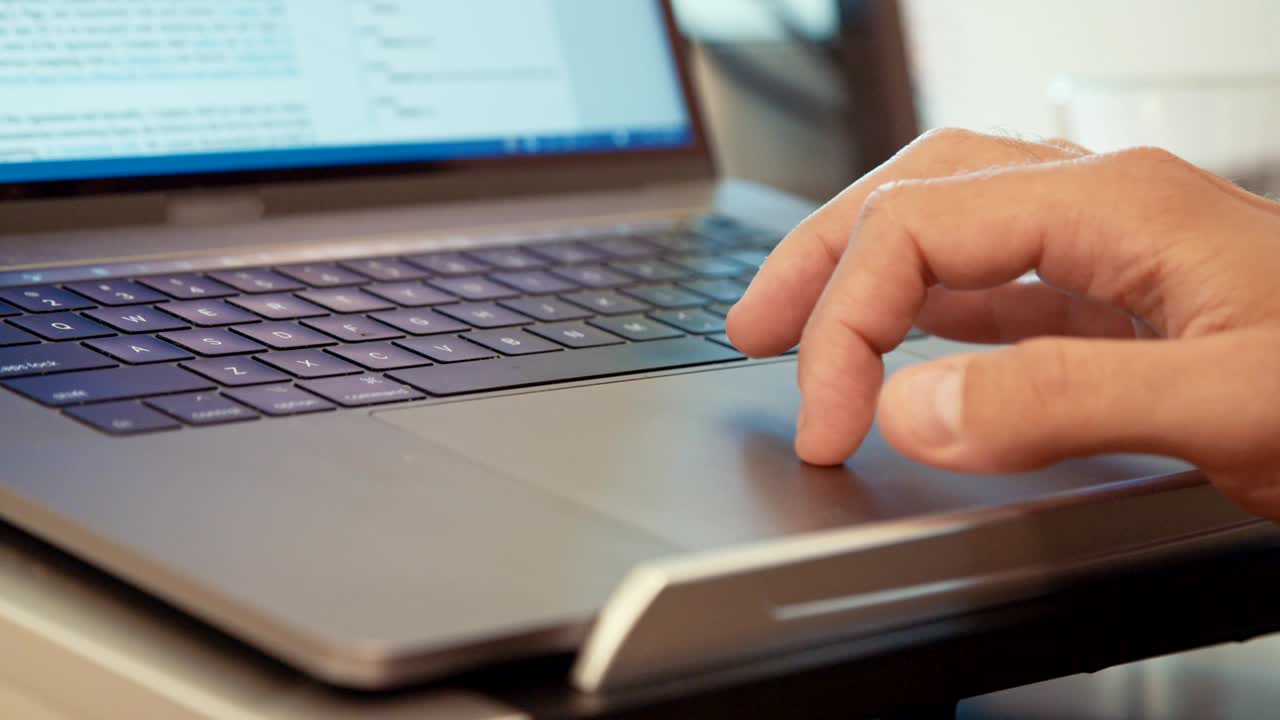 manos del hombre escribiendo en un teclado de computadora portátil