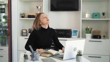 la mujer rubia está sentada en una mesa y hablando por zoom, es emocional y alegre, está enojada, agresiva, irritada, insatisfecha con la conversación con el interlocutor