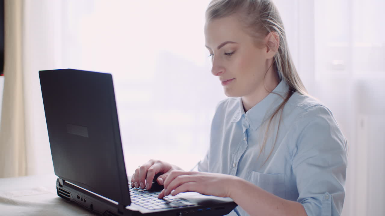 mujer sonriente que trabaja en la computadora portátil en la oficina en casa empresaria escribiendo en el teclado de la computadora 9