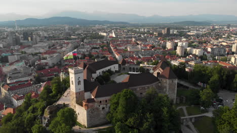 flying over ljubljana castle with drone in overseeing the city buildings