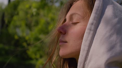 cara de primer plano en el perfil de una joven mujer caucásica disfrutando del sol al aire libre