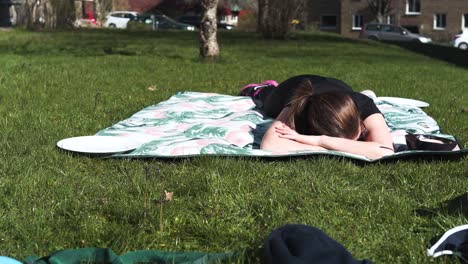 mujer recostada sobre una manta al sol después de un duro entrenamiento, totalmente agotada-1