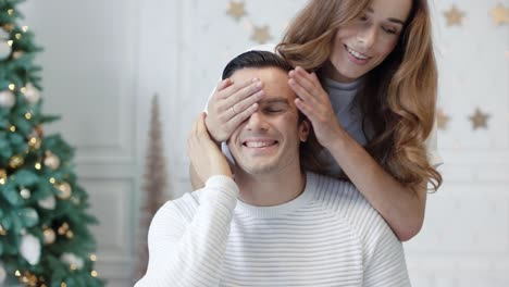 familia sonriente celebrando el año nuevo en una casa de lujo. bonita esposa presentando regalo