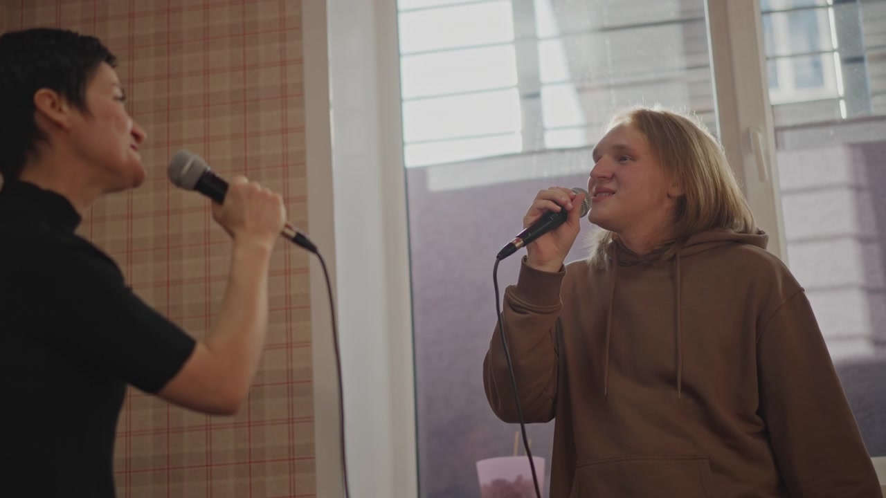 Call and response-duettøvelse nær vinduslys med to sangere som utveksler fraser, nært mikrofonarbeid, pusteøvelser, improviserte harmonier, relasjonsbygging og auditionforberedelse