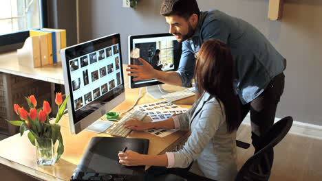 diseñador gráfico masculino y femenino trabajando en computadora