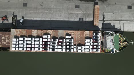 Vehicles-parked-on-deck-of-international-cargo-carrier-vessel-on-Montevideo-harbour-port,-Birdseye-aerial-view