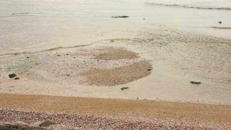 closeup shot of a beach with oceanwater coming on shore.