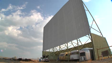 A-time-lapse-shot-of-clouds-passing-over-an-abandoned-drive-in-theater-screen-1