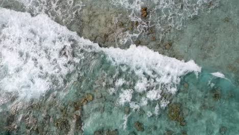 drone footage of crystal clear blue water and waves on the shore of beach in thailand