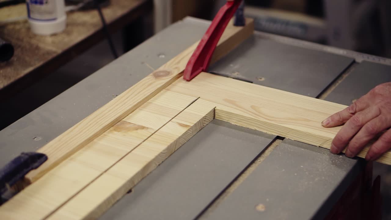 imágenes de alto ángulo de corte de tablero de madera en una máquina de sierra. acción. máquina industrial con sierra circular corta tablero de madera. manos masculinas sosteniendo un patrón