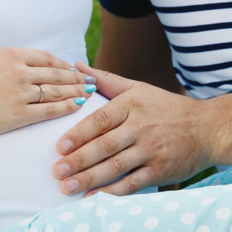 manos de hombre y mujer en el vientre del embarazo
