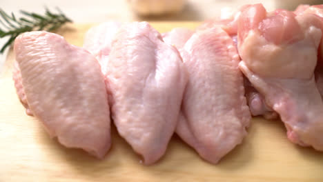 fresh raw chicken wings on wooden board with ingredients