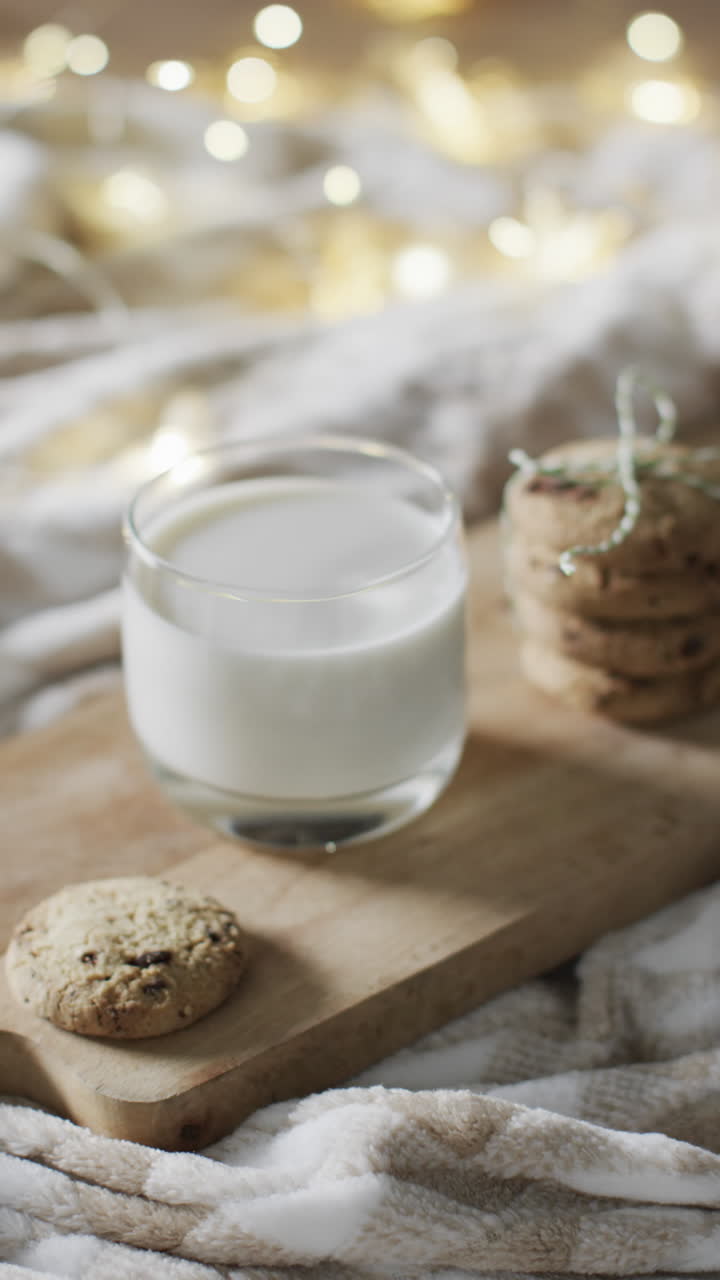 Vertical video of mug of milk and christmas cookies and copy space on white background